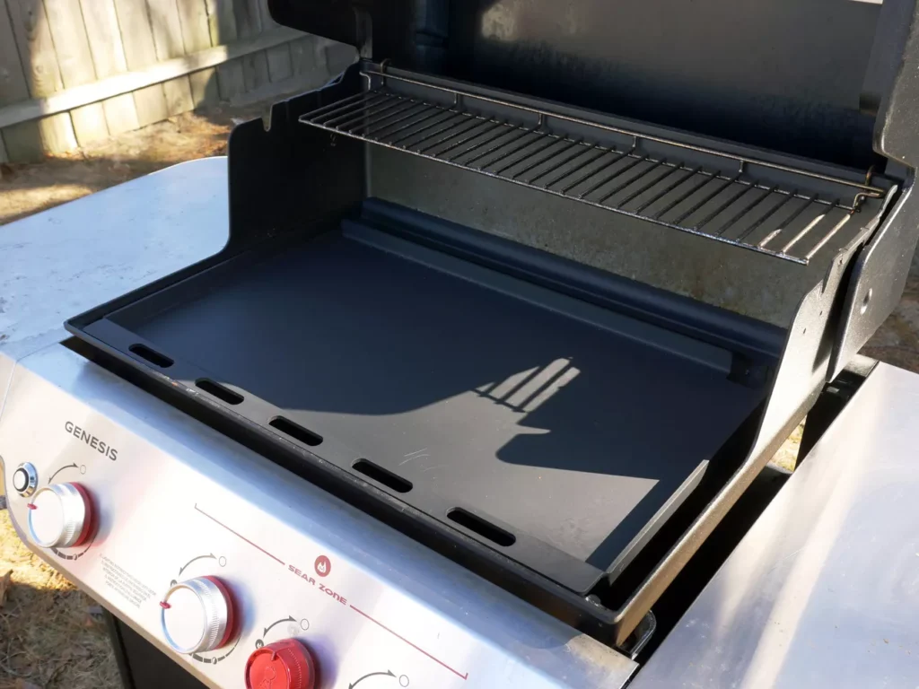 Outdoor brunch cooking on a cast iron griddle with bacon and eggs